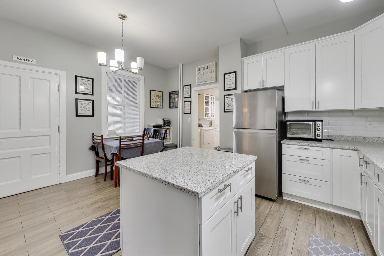 7330 North Honore Street Chicago, IL 60626 - Photo 10 of 43 a kitchen with refrigerator cabinets and wooden floor