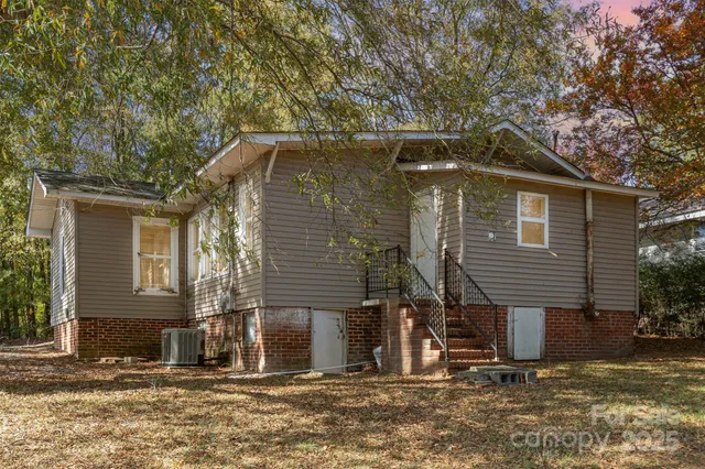 a front view of a house with large trees