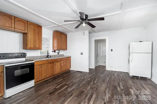 a kitchen with a refrigerator and white cabinets