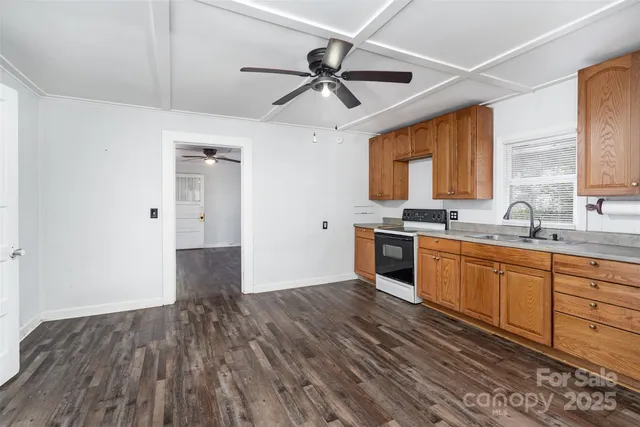 a kitchen with granite countertop a stove cabinets and a wooden floor