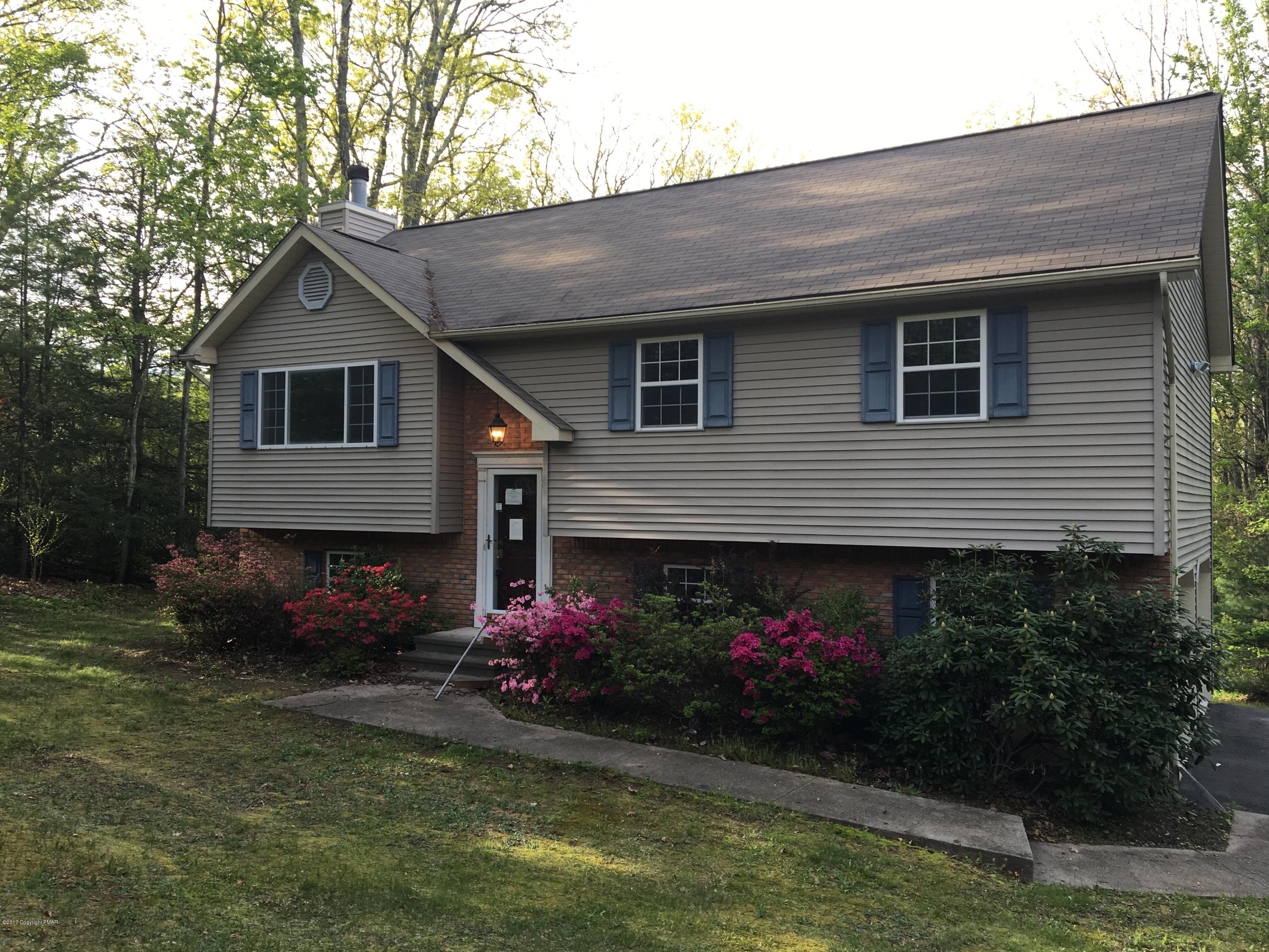 a front view of a house with a yard and a garden