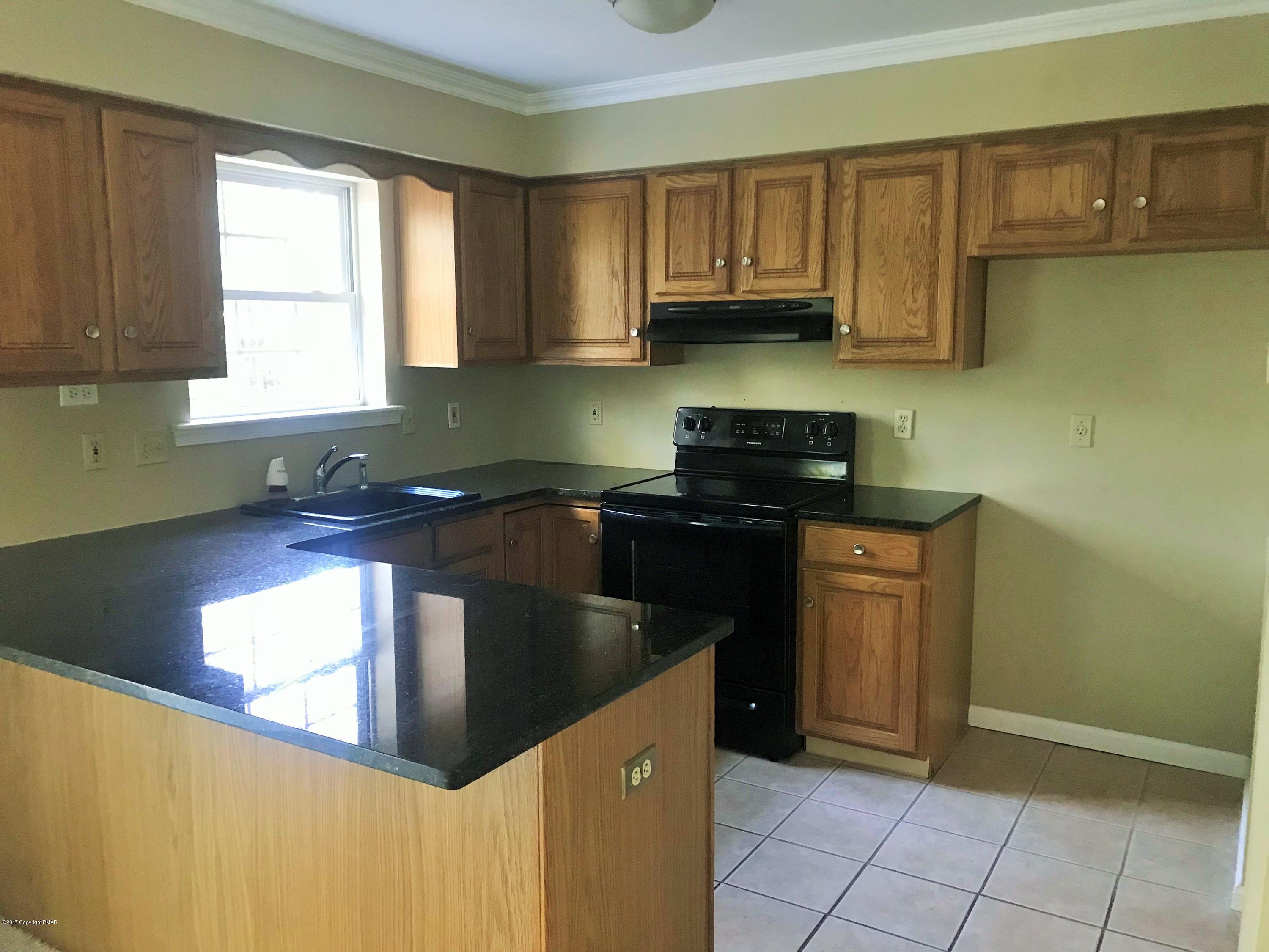 2185 Hill Road Effort, PA 18330 - Photo 16 of 17 a kitchen with granite countertop a sink a stove and cabinets
