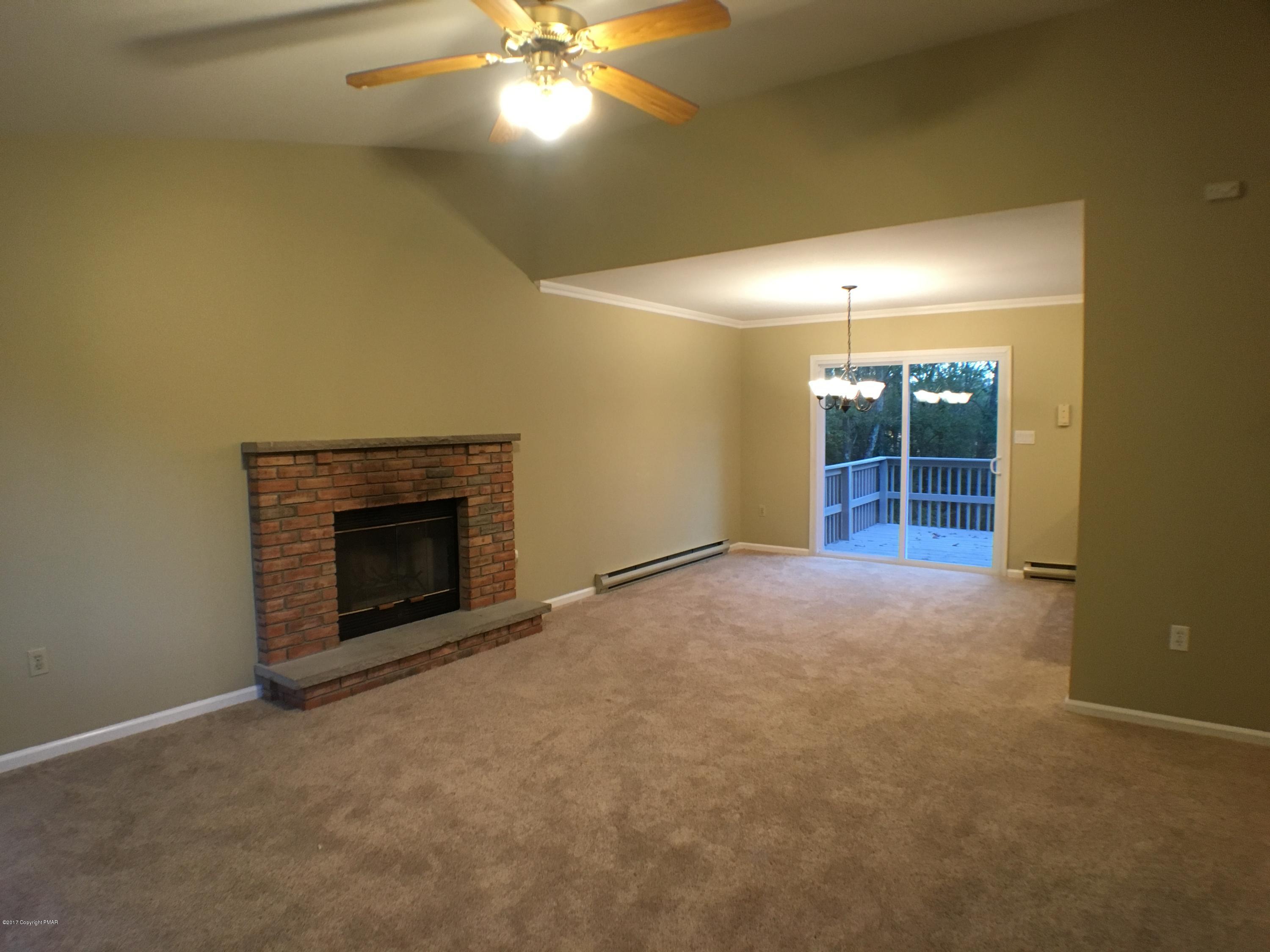 2185 Hill Road Effort, PA 18330 - Photo 3 of 17 an empty room with a fireplace and fan