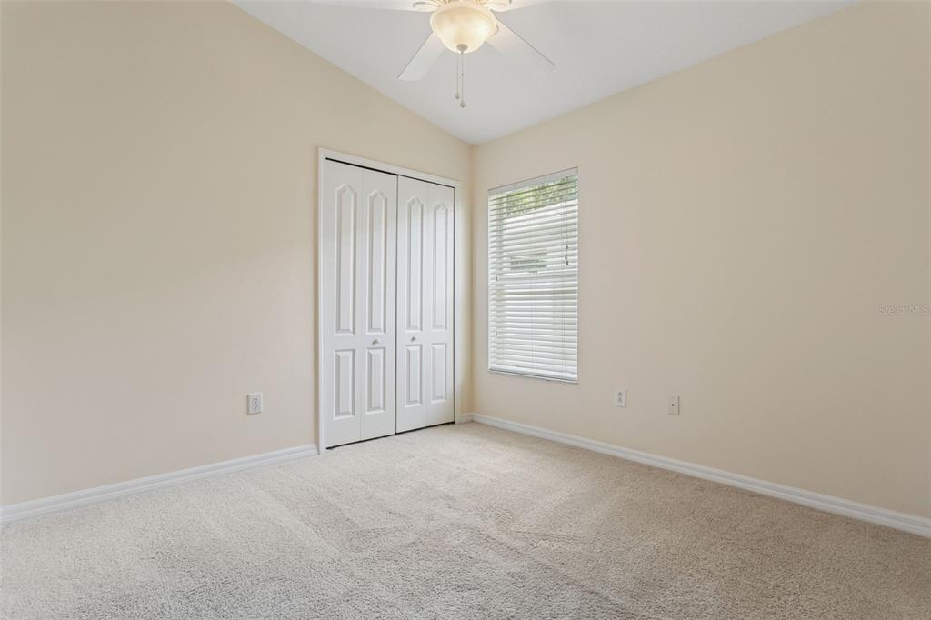 25932 Terrawood Loop Land O Lakes, FL 34639 - Photo 16 of 28 an empty room with a chandelier fan and windows