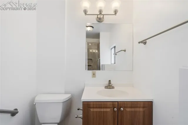 a bathroom with a sink toilet and a mirror