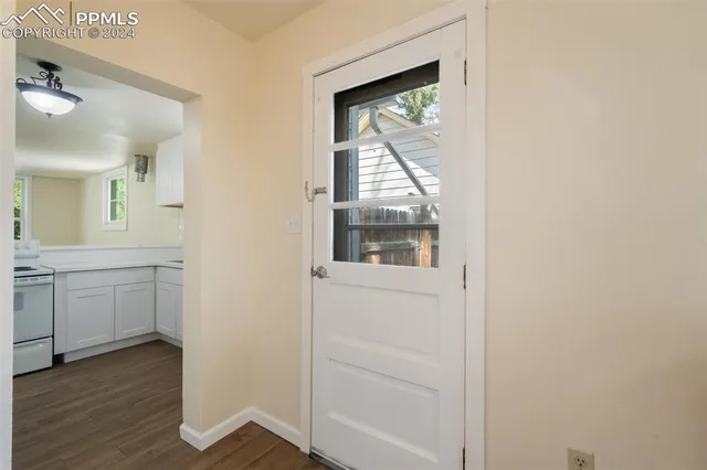a view of hallway with window and wooden floor