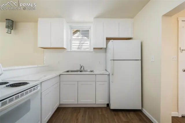 a kitchen with white cabinets and white appliances