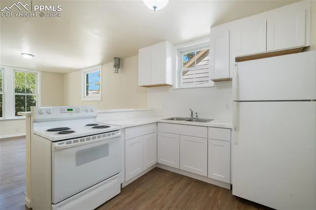 a kitchen with white cabinets and white appliances