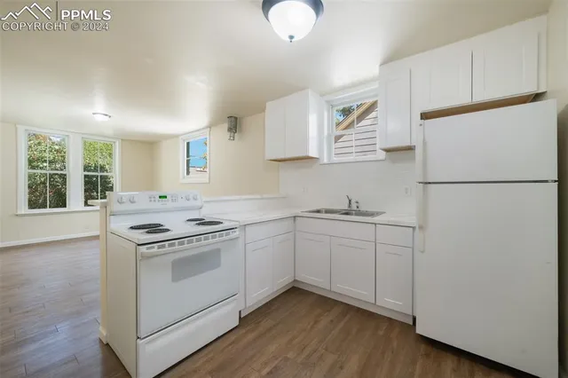 a kitchen with white cabinets and white appliances