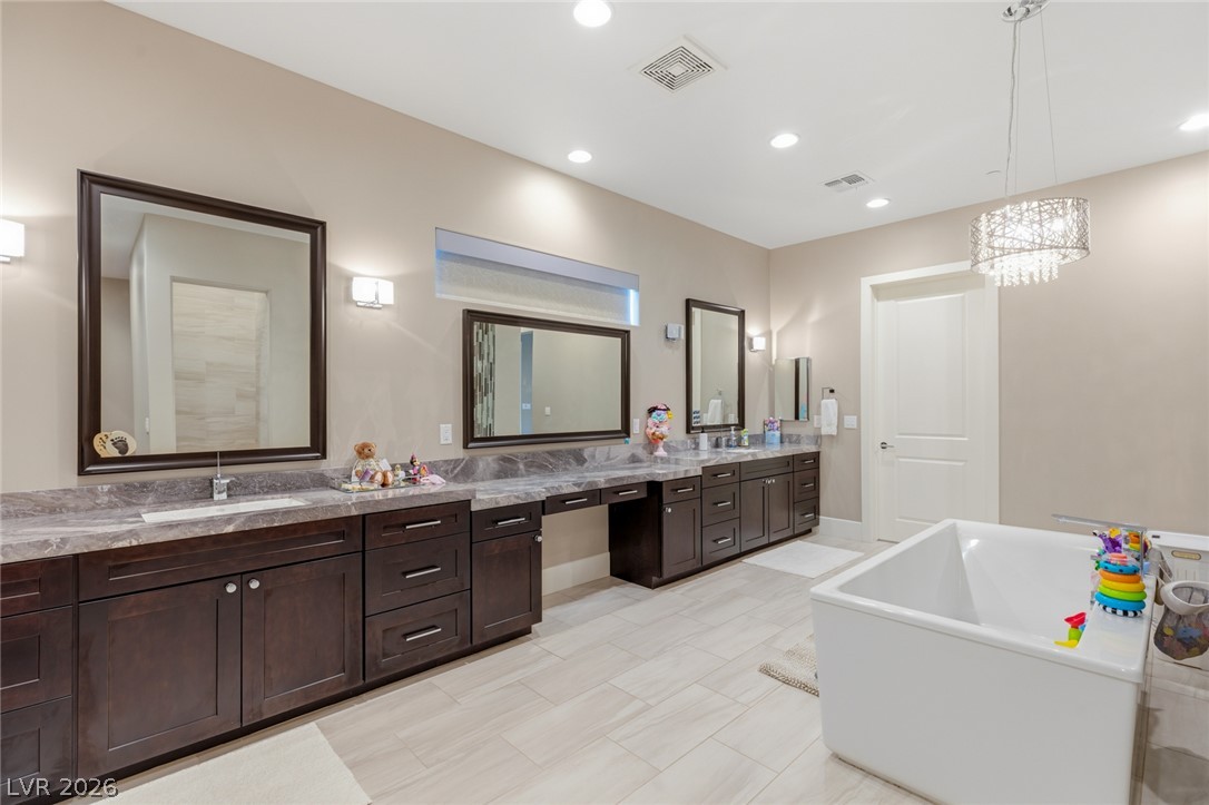 5 Crystal Tree Pass Henderson, NV 89052 - Photo 33 of 67 Indulge in a primary bathroom designed for rejuvenation, featuring a deep soaking tub and a spacious dual vanity.