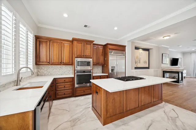 a kitchen with stainless steel appliances kitchen island granite countertop a stove and a sink