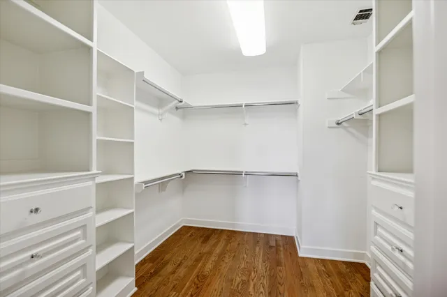 a view of a brick house with large trees next to a yard
