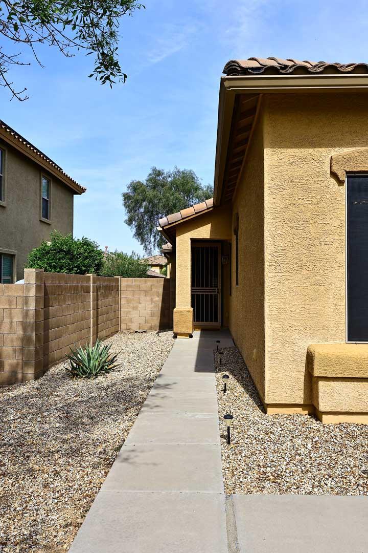 a backyard of a house with potted plants and floor to ceiling window