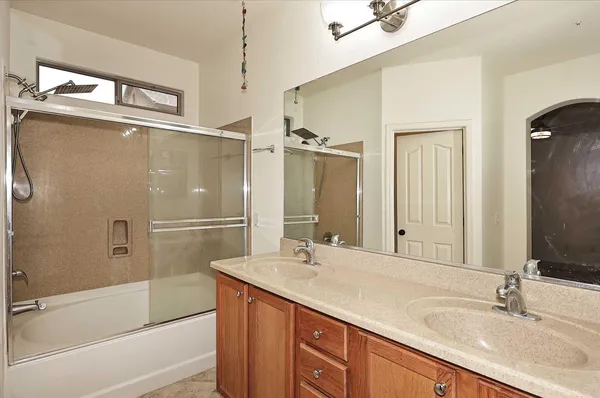 a bathroom with a granite countertop sink mirror bathtub and shower