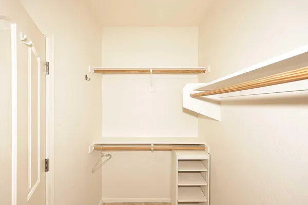 a view of walk in closet with empty racks