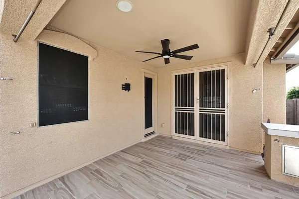 a view of a hallway with wooden floor and a ceiling fan