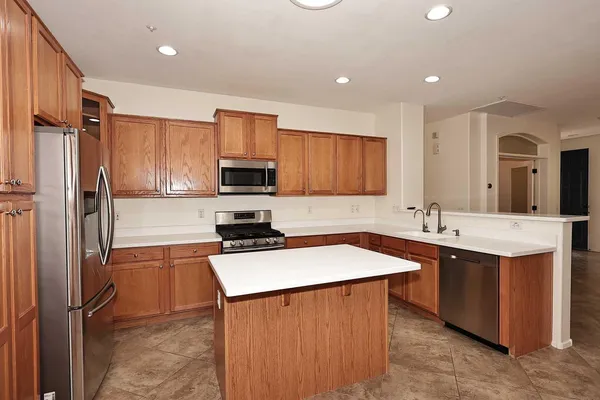 a kitchen with stainless steel appliances a sink stove refrigerator and cabinets
