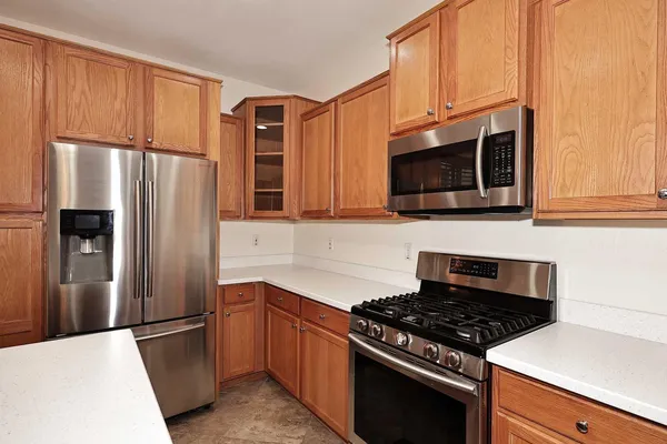a kitchen with stainless steel appliances granite countertop a refrigerator stove top oven and sink