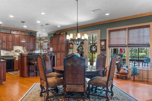 a kitchen with stainless steel appliances granite countertop a stove top oven a refrigerator a sink and dishwasher with wooden floor