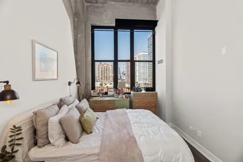 a bedroom with a bed and a large window