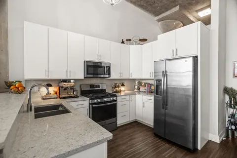 a kitchen with stainless steel appliances granite countertop a refrigerator sink and stove