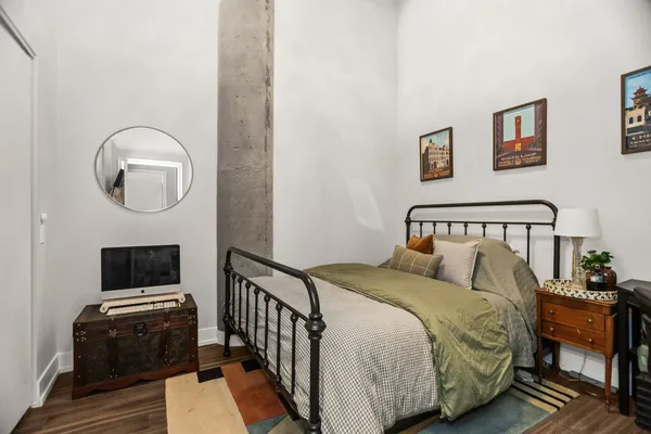 a bedroom with a bed and wooden floor