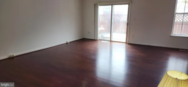 a view of an empty room and wooden floor and a window