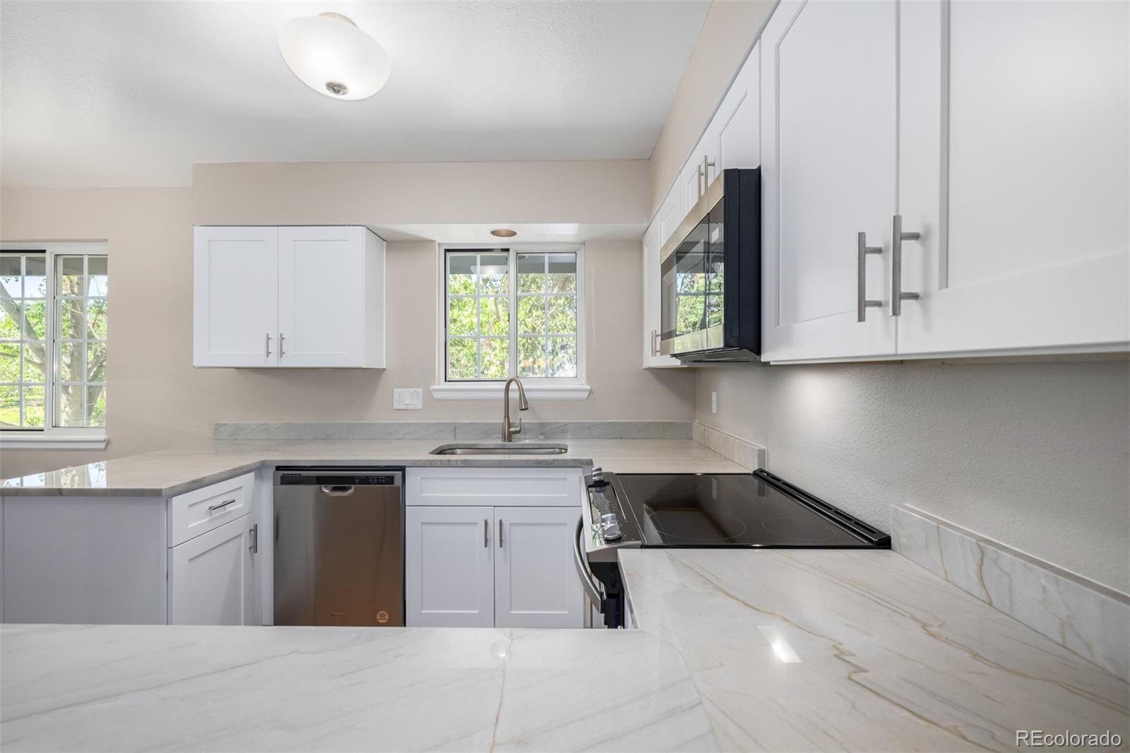 10401 West Red Mountain Road Littleton, CO 80127 - Photo 11 of 40 a kitchen with stainless steel appliances granite countertop a sink a stove and cabinets