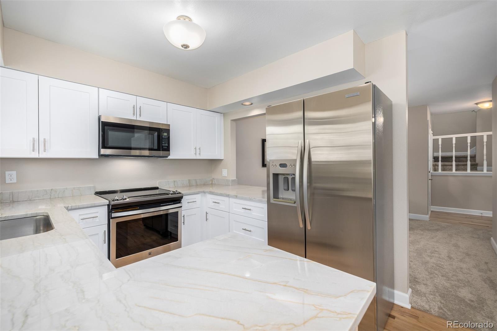 10401 West Red Mountain Road Littleton, CO 80127 - Photo 15 of 40 a kitchen with stainless steel appliances granite countertop a refrigerator a stove a sink and a microwave