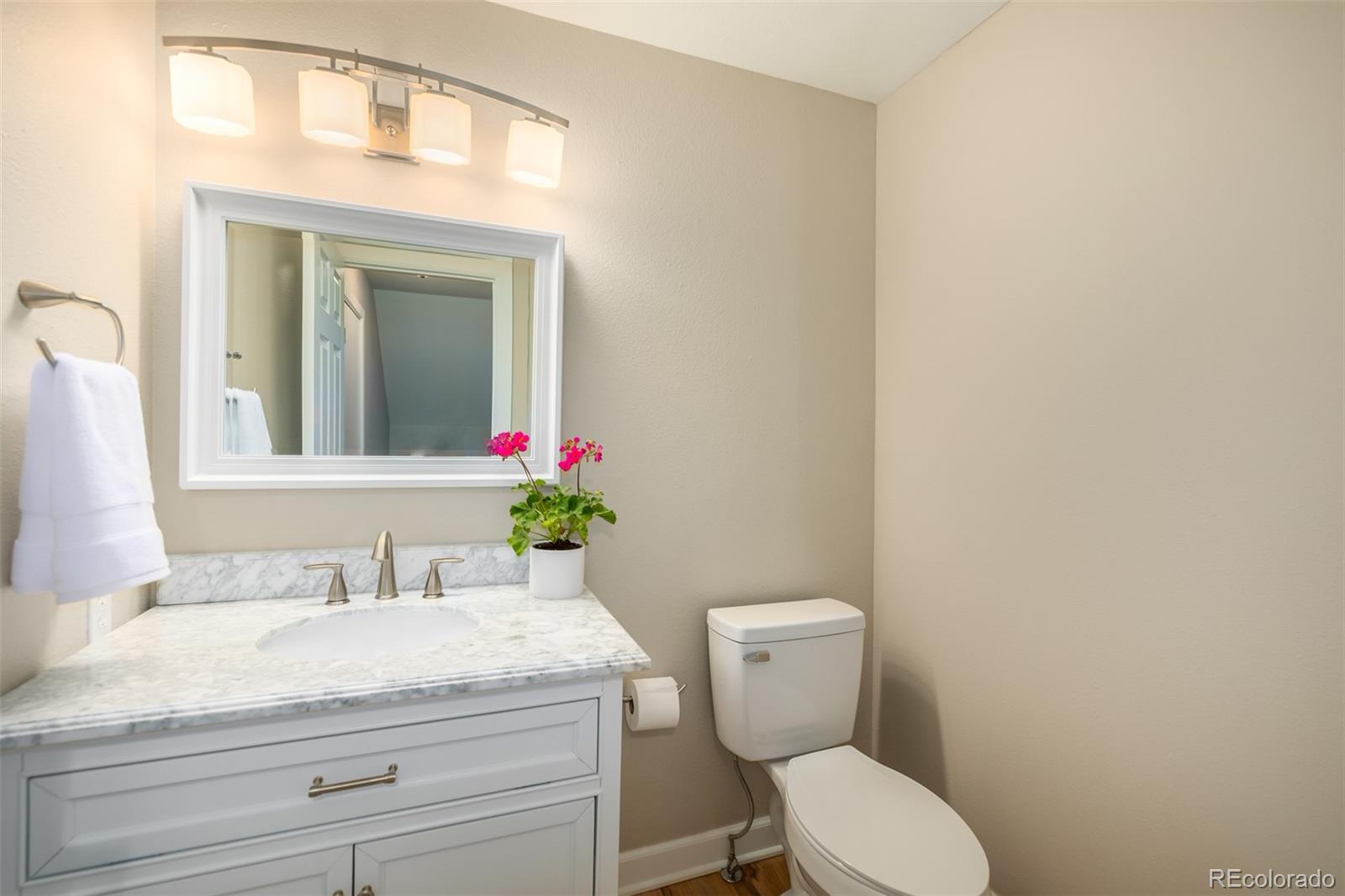 10401 West Red Mountain Road Littleton, CO 80127 - Photo 16 of 40 a bathroom with a granite countertop toilet sink and mirror