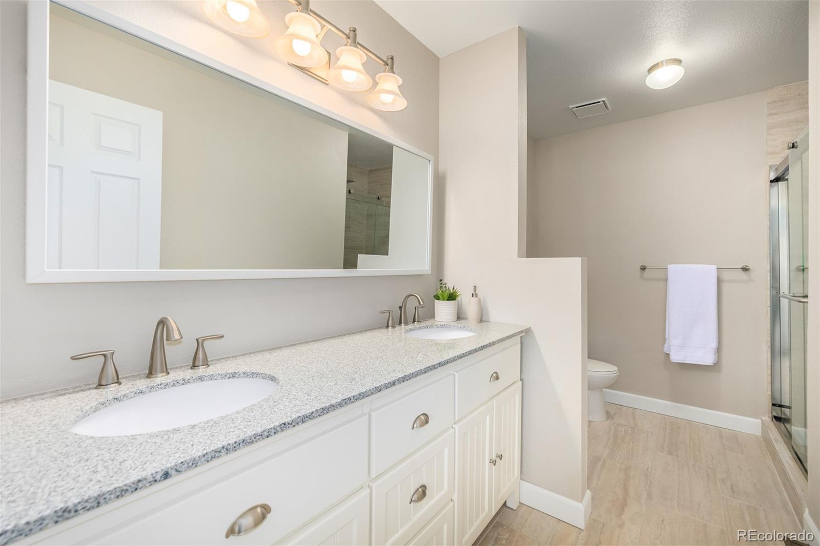 10401 West Red Mountain Road Littleton, CO 80127 - Photo 21 of 40 a bathroom with a granite countertop sink and a mirror