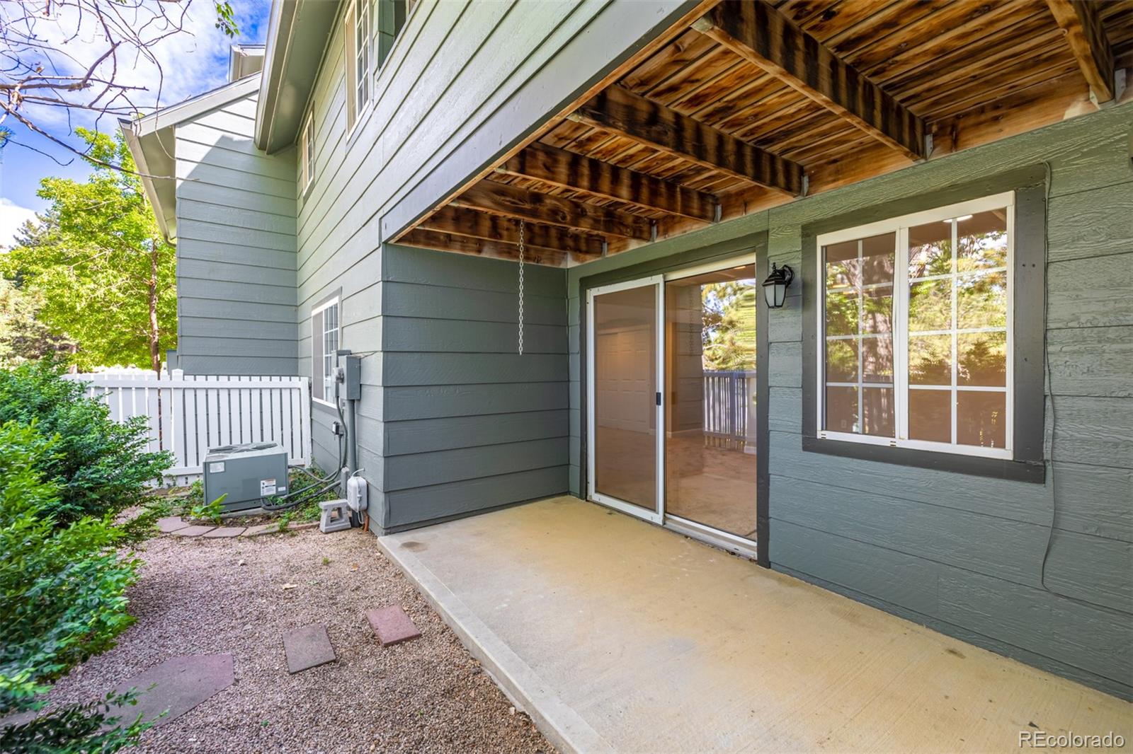 10401 West Red Mountain Road Littleton, CO 80127 - Photo 37 of 40 a view of yellow house with a large window and flower plants