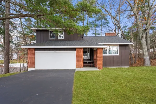 a front view of a house with yard and garage