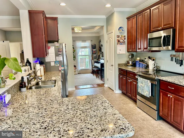 a kitchen with stainless steel appliances granite countertop a stove refrigerator and sink