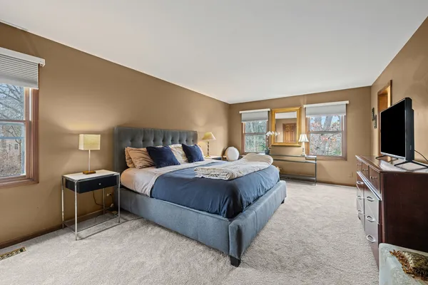 a bedroom with a bed and a flat tv screen on dresser