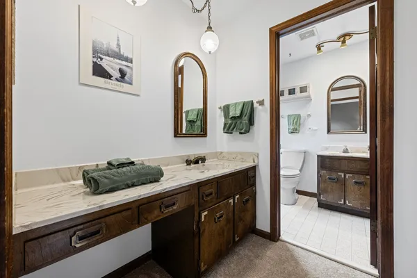 a spacious bathroom with a granite countertop sink a mirror and shower