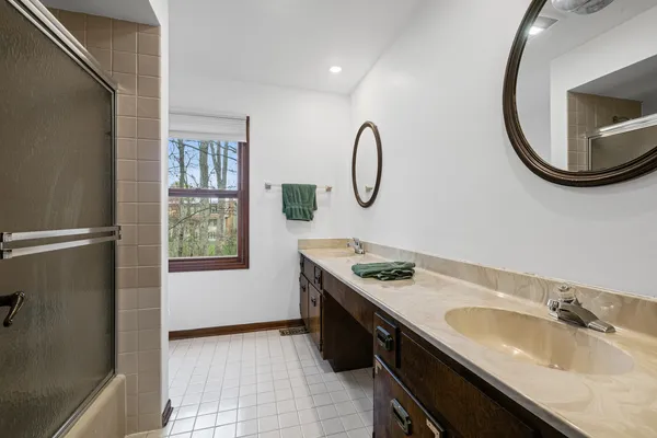 a bathroom with a granite countertop sink a mirror and a shower