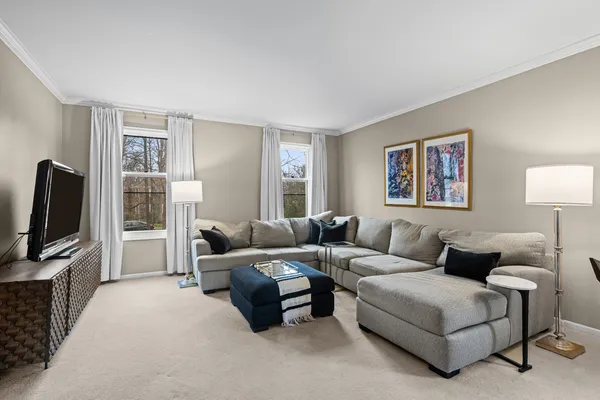 a living room with furniture a flat screen tv and a window