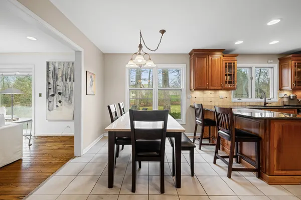 a dining room with furniture a chandelier and wooden floor