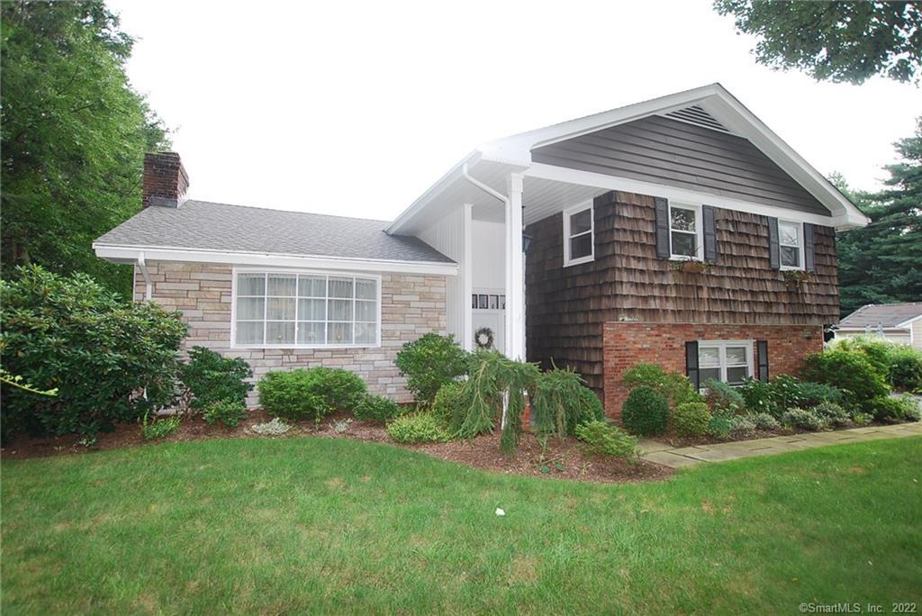 a front view of a house with a yard and potted plants