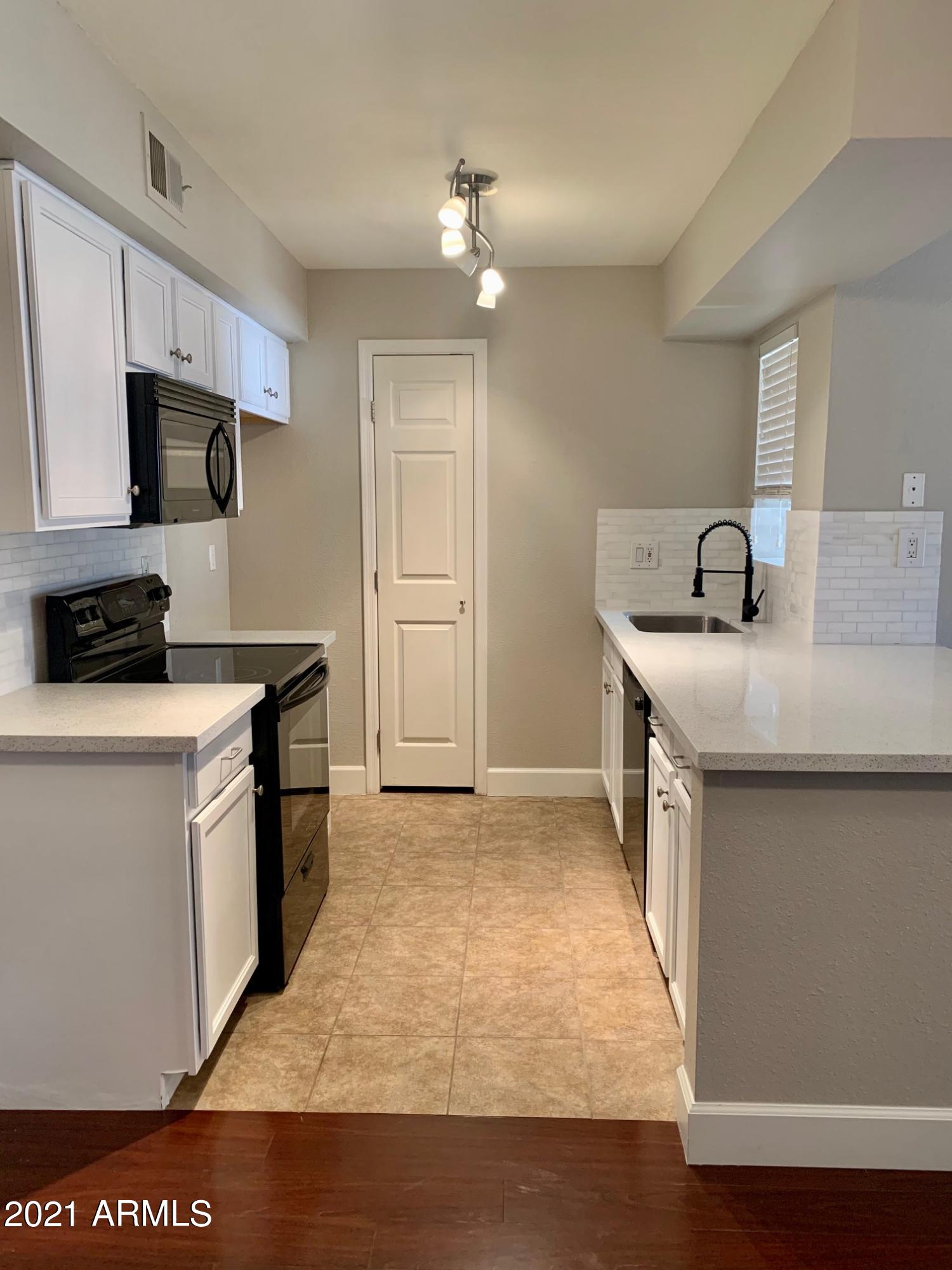 2625 East Indian School Road, Unit 101 Phoenix, AZ 85016 - Photo 2 of 15 a kitchen with a sink a stove and refrigerator