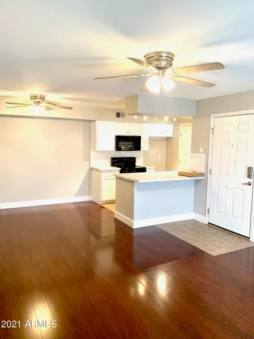a view of a kitchen with wooden floor and a sink