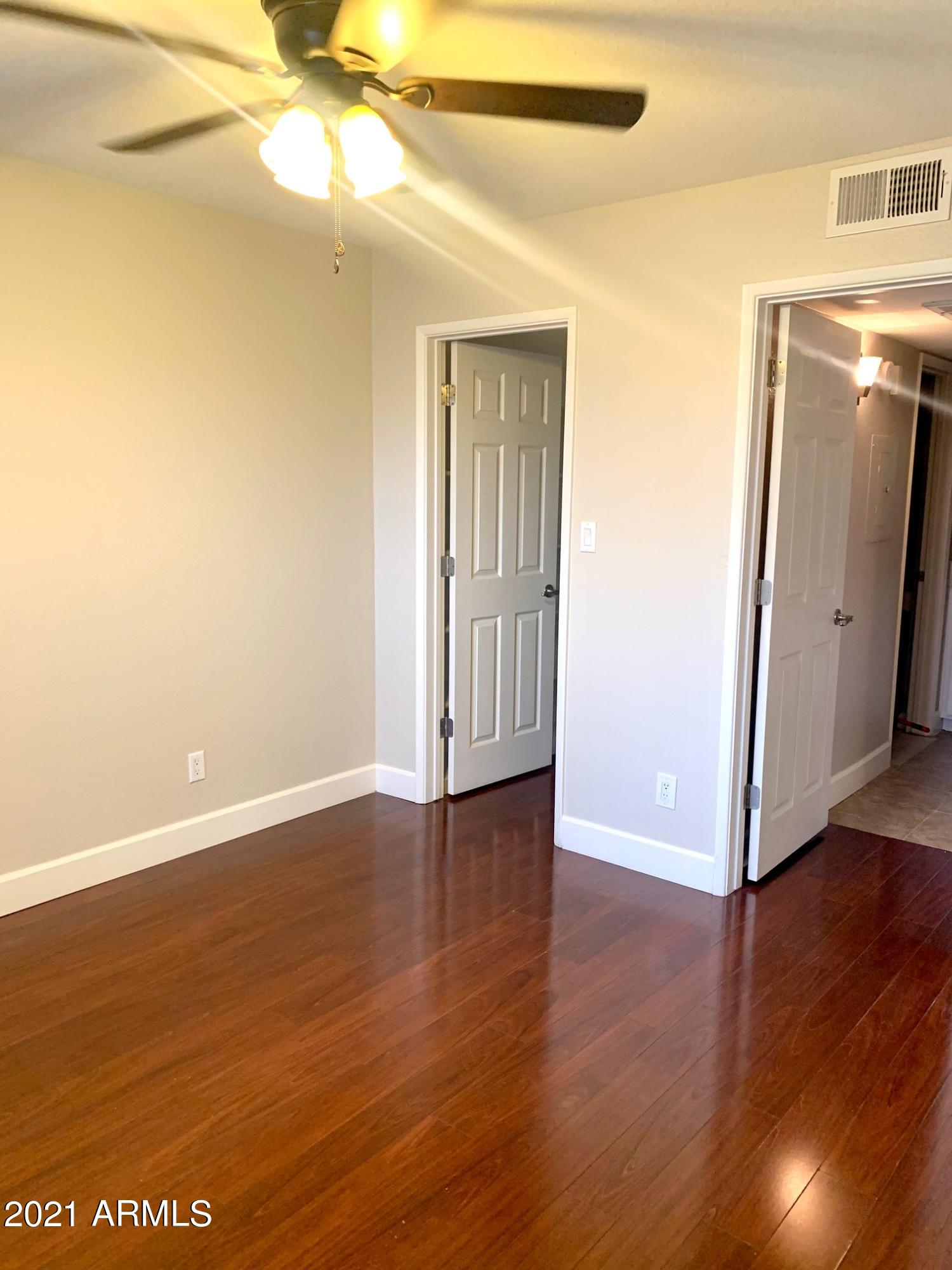 2625 East Indian School Road, Unit 101 Phoenix, AZ 85016 - Photo 7 of 15 a view of an empty room with wooden floor and a window