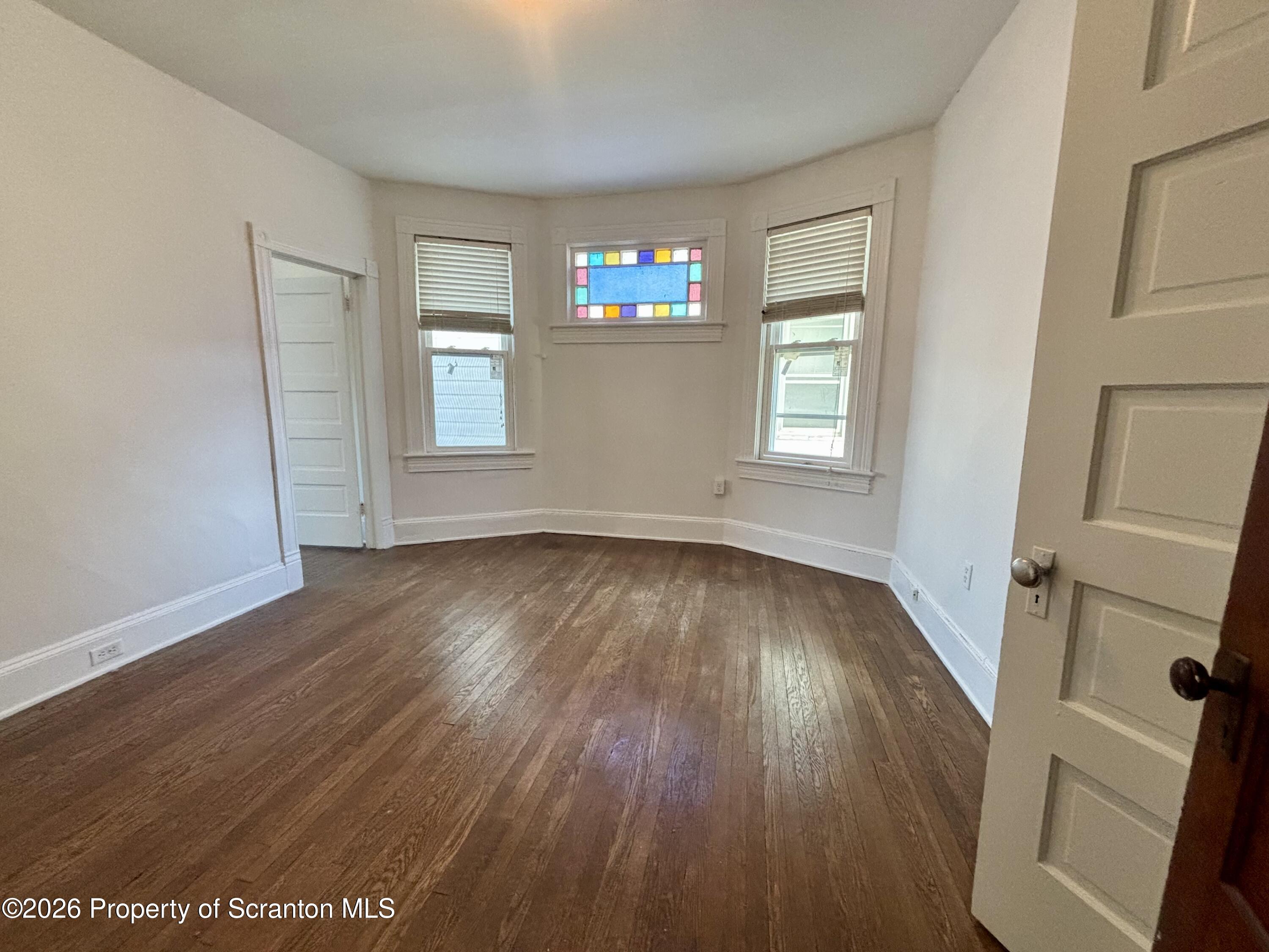 218 South Main Avenue Scranton, PA 18504 - Photo 3 of 9 an empty room with wooden floor and windows