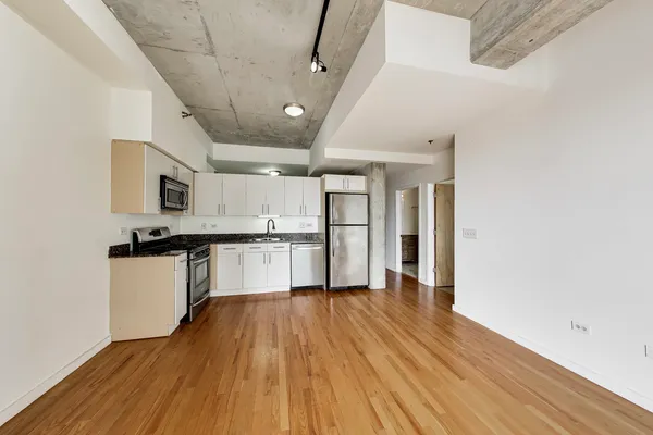 a view of a kitchen with a refrigerator a stove top oven and cabinets