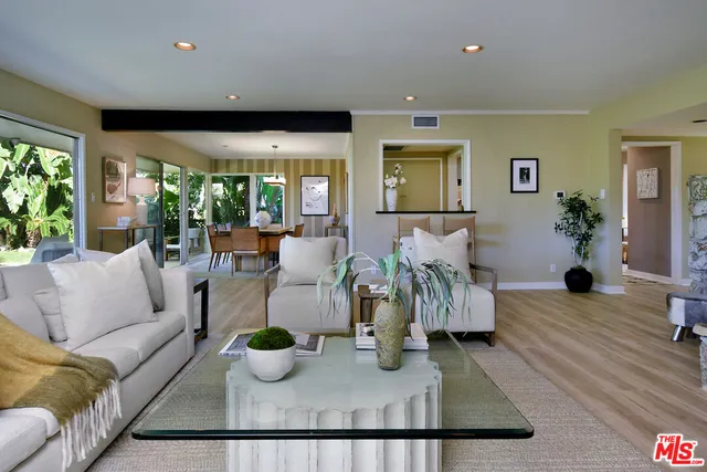 a dining room with wooden floor a chandelier a wooden table and chairs