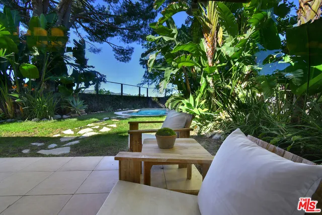 a view of backyard with outdoor seating and plants