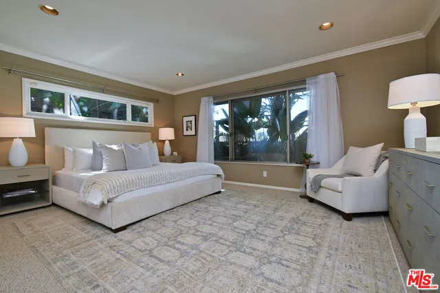 a bedroom with a bed and a large window