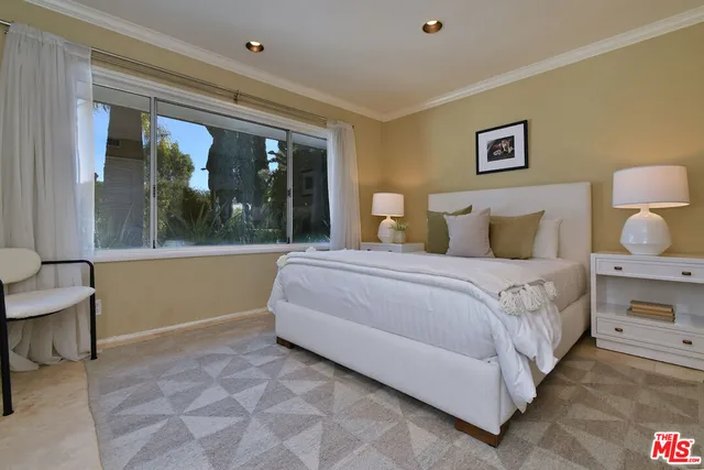 a bedroom with a bed a desk and chair with the mirror