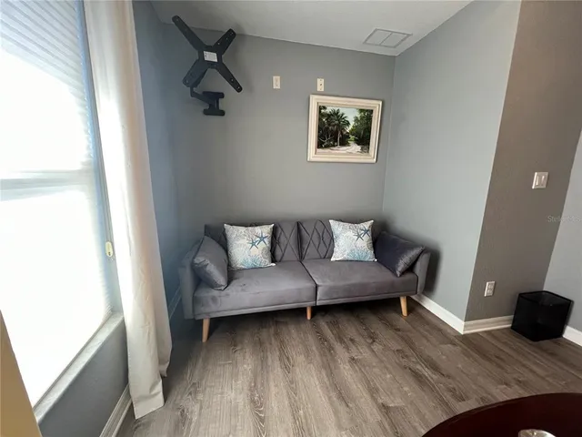 a living room with furniture and a wooden floor
